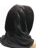 Detail view black jersey shawl end with black mink pompon showing texture contrast between fur and jersey fabric