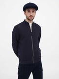 Back view man wearing navy newsboy cap with dark jacket showing rear fit