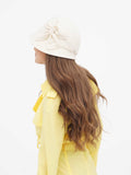 Close-up of beige wool cloche hat with side bow and yellow collar
