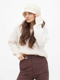 Woman adjusting beige wool cloche hat, standing three-quarter pose