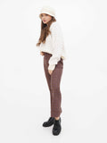 Full-length photo of woman in cream sweater wearing beige cloche hat, side view
