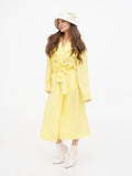 Woman in beige cloche hat and yellow dress, front-facing view