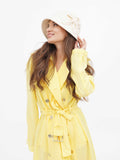 Woman in beige cloche hat and yellow dress, side view