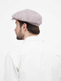 Man in beige 8-panel newsboy cap full body view with hands in pockets casual pose