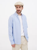 Man in beige linen newsboy cap full body side view
