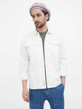 Side profile close-up of man wearing beige 8-panel slouchy newsboy cap with white shirt