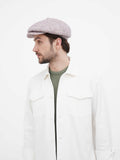 Beige 8-panel baker boy hat torso profile view showing slouchy fit with white shirt