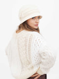 Woman wearing beige wool cloche hat, close-up front view
