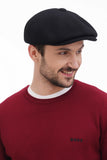 Side profile man wearing black wool newsboy cap with burgundy sweater casual smile