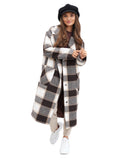 Three-quarter view woman in black baker boy hat with checked coat