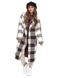 Side view of woman in black cashmere paperboy cap with plaid coat