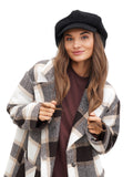 Portrait of smiling woman wearing black cashmere newsboy cap