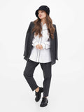Woman in black cloche hat and blazer, three-quarter view