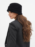 Woman in grey blazer wearing black cloche hat, side profile close-up