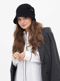 Full-length view of black cloche hat with white jacket and dark pants