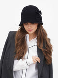 Woman in black cloche hat and white shirt with dark blazer, front view