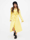 Full-length view of woman in black cloche hat and yellow trench coat