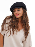Close-up of woman wearing black 8-panel cotton newsboy cap showing crown detail