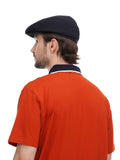 Back view of man in black flat cap showing construction detail with orange shirt visible