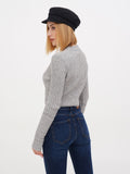 Woman in black linen baker boy cap, grey sweater and jeans full length