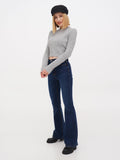Woman wearing black linen Breton cap, grey sweater and jeans standing