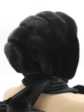 Three-quarter back view black mink black suede striped fur hat hood with black fabric ties and pompons