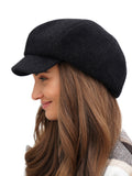 Front close-up of woman wearing black cashmere newsboy cap with long hair