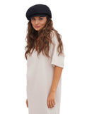 Front portrait of woman wearing black cotton paperboy hat white background