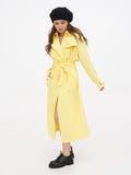 Black wool beret hat on woman in yellow trench coat, full length front view autumn winter outfit
