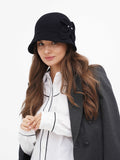 Woman wearing black wool cloche hat with side bow detail, dark blazer and white shirt