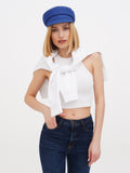 Woman in blue linen baker boy cap, white top and dark jeans full length