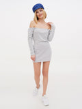 Woman wearing blue linen baker boy cap and grey dress standing full length