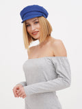 Close-up of woman in blue linen Breton cap with off-shoulder grey top