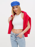 Close-up of woman in blue linen Breton cap adjusting red cardigan
