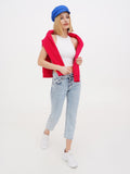 Woman wearing blue linen Breton cap with red cardigan and white top, full length
