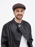 Man wearing brown linen newsboy cap front view with leather jacket