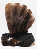 Brown mink and brown suede striped fur hat cowl with black fabric ties and pompons on mannequin, back three-quarter view