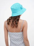 Back view of woman in turquoise bucket hat and striped summer dress