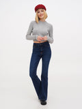 Woman wearing burgundy Breton cap with gray sweater and dark jeans full length