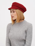 Woman wearing burgundy linen Breton cap with gray ribbed sweater, side profile