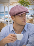 Burgundy linen newsboy hat men three quarter view tropical setting