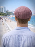 Man in burgundy newsboy cap holding coffee cup casual style