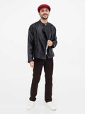 Full body shot man wearing burgundy wrinkled linen newsboy hat with black leather jacket dark pants