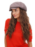 Woman in red top wearing cappuccino brown cotton newsboy cap close-up portrait