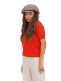 Three-quarter view of woman wearing cappuccino brown cotton paperboy hat