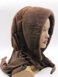 Chocolate brown mink fur hat hood with light brown fabric scarf on mannequin, front three-quarter view showing two-tone brown