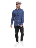 Three quarter view man wearing cocoa flat cap with denim shirt casual stance