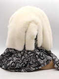 Side profile cream mink fur hat hood cowl on mannequin showing mink pompon at cowl join and knit drape
