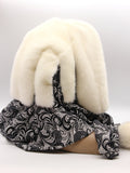 Three-quarter view cream mink fur hat hood showing ivory mink surface and black knit cowl contrast