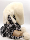 Three-quarter back view cream mink fur hat hood showing ivory mink crown and black patterned ties with pompons
